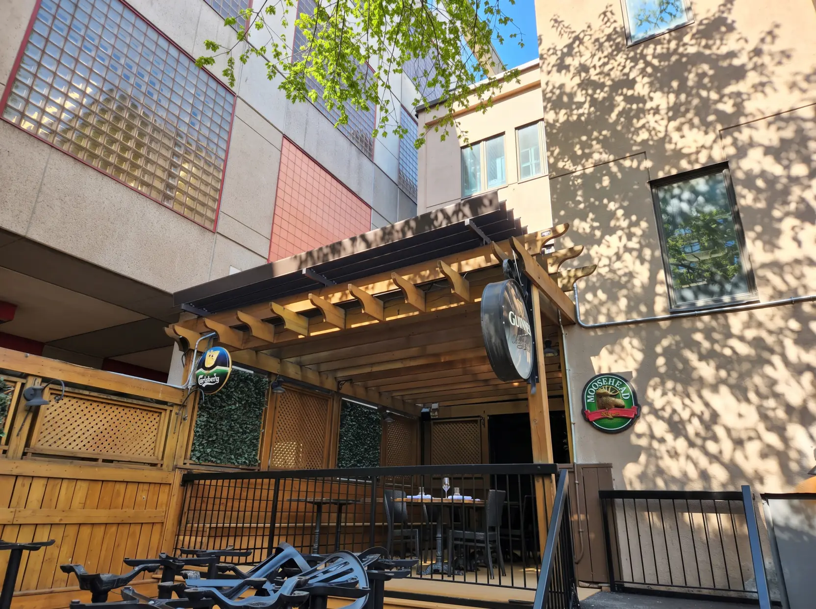Pergola de bois au-dessus de la terrasse du pub entre les bâtiments, Mckibbin's Irish Pub à Montréal