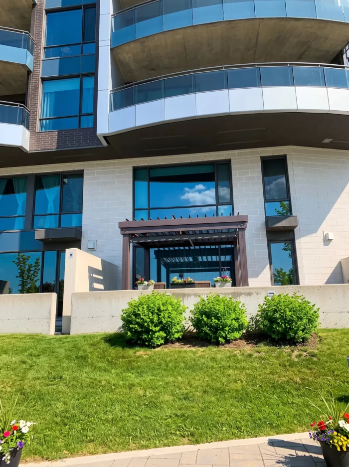 Façade vitrée courbe et ses aménagements paysagers, Métis Condos à Québec