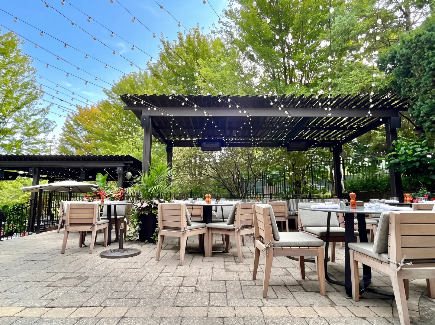 Terrasse de jardin sous une pergola noire et ses guirlandes lumineuses, Miller Tavern à Toronto