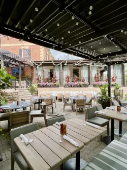 Tables dressées sous la pergola noire à lames, Miller Tavern à Toronto
