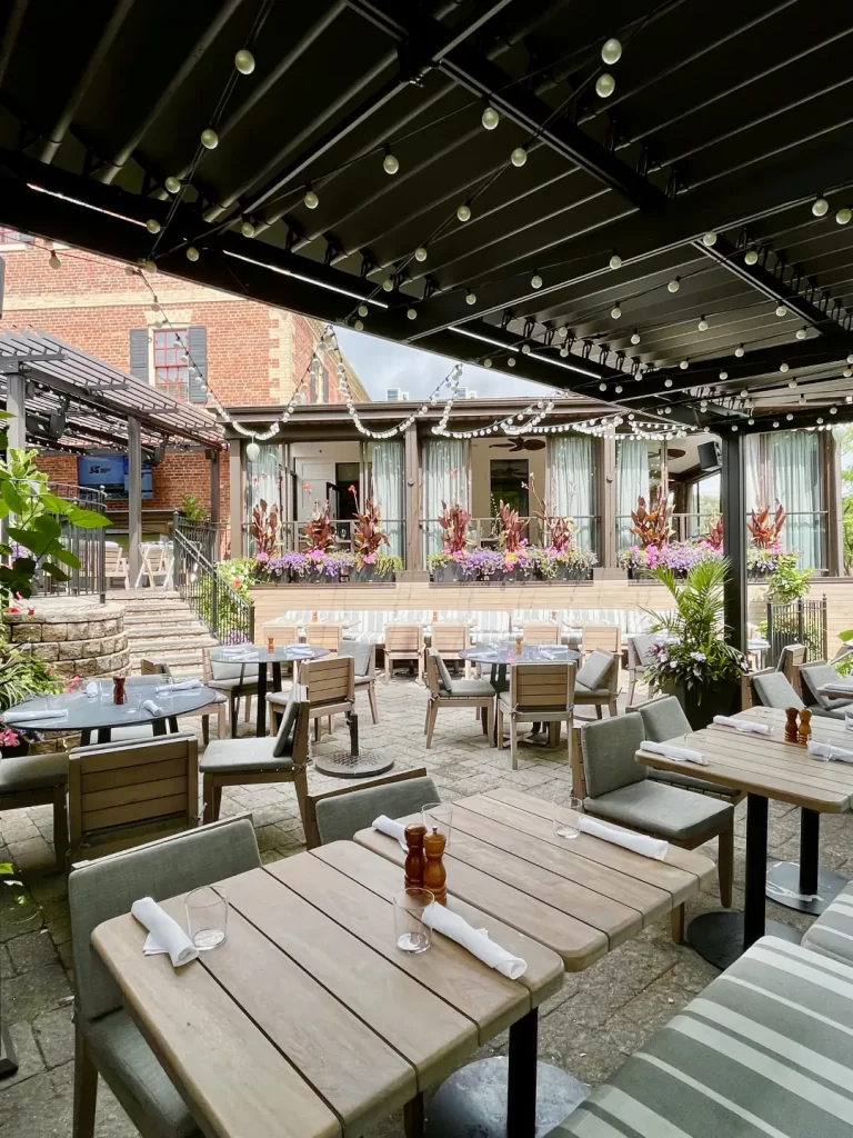 Tables dressées sous la pergola noire à lames, Miller Tavern à Toronto