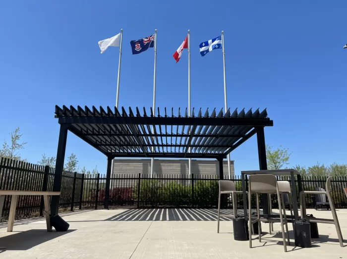 Black pergola on the paved area in front of the flagpoles, Molson Coors in Saint-Hubert