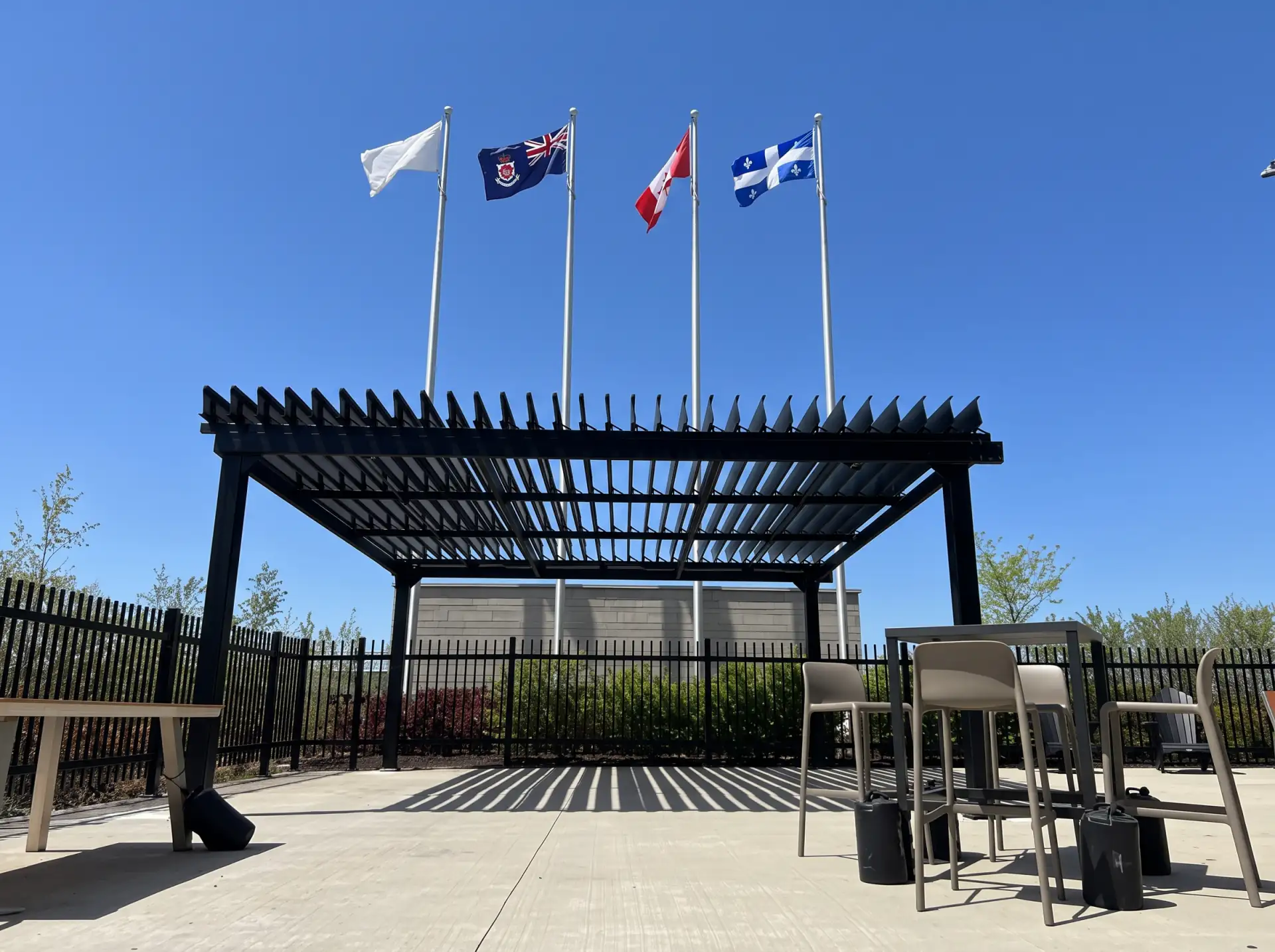 Black pergola on the paved area in front of the flagpoles, Molson Coors in Saint-Hubert