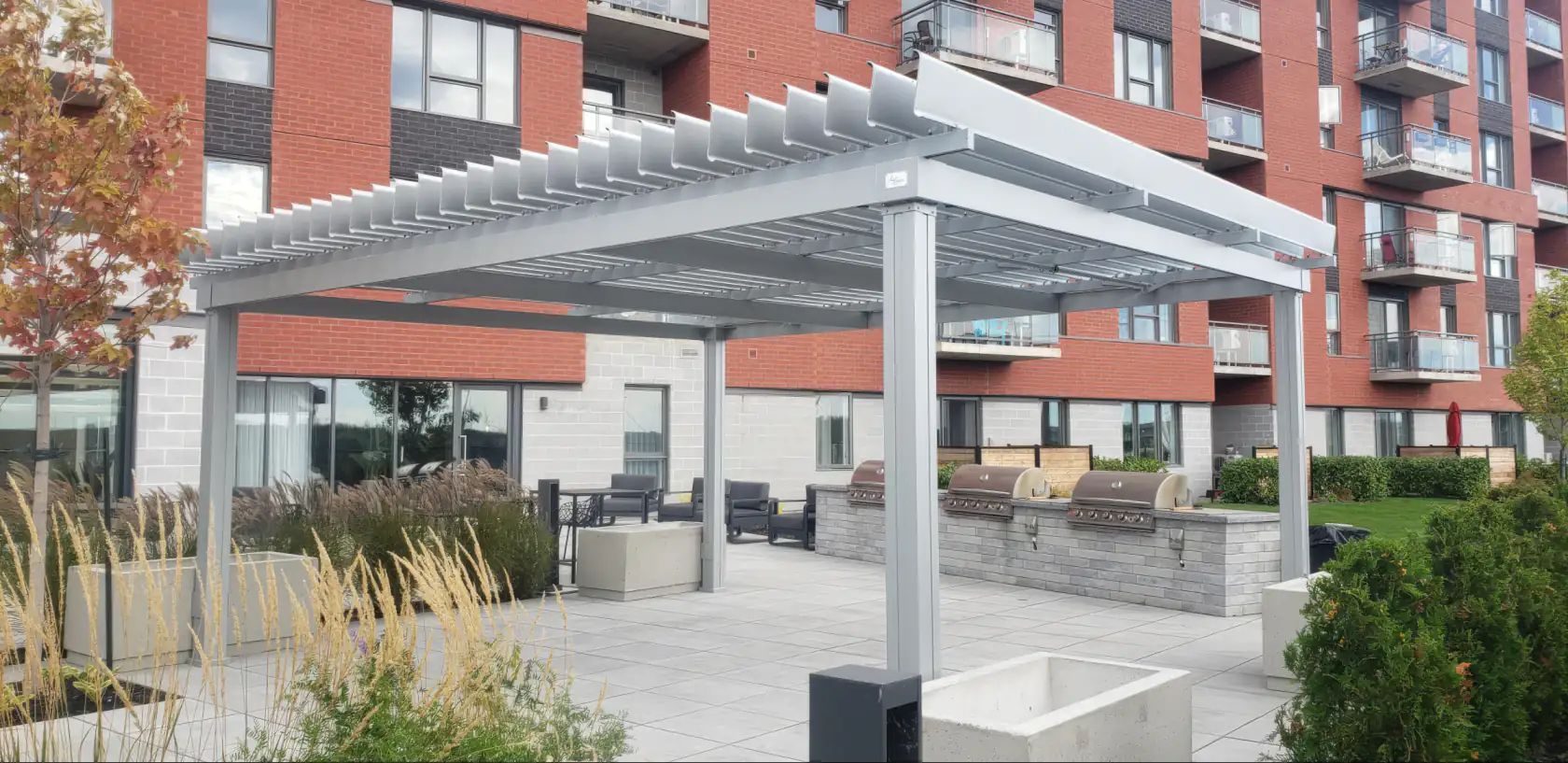 Pergola blanche au-dessus de la terrasse entre les immeubles, Condos Mostra Candiac
