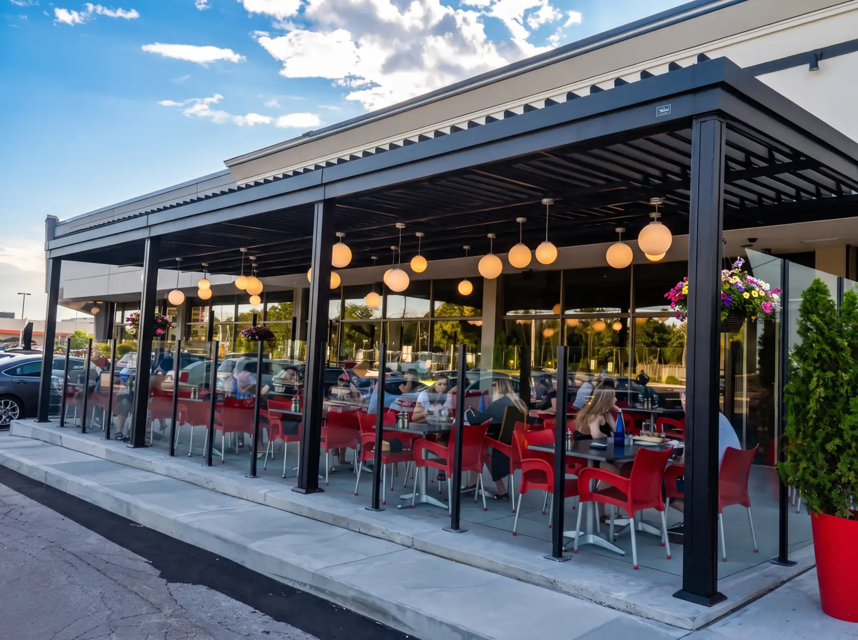 Long black pergola over the glazed terrace and its globe lights, Pacini in Trois-Rivières