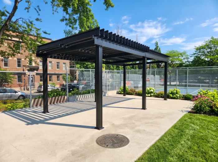 Black pergola over a park slab near the fenced court, Parc Sir-George-Étienne-Cartier in Montréal