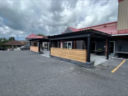 Terrasse et paravent de bois vus du stationnement, La Piazzetta à Granby