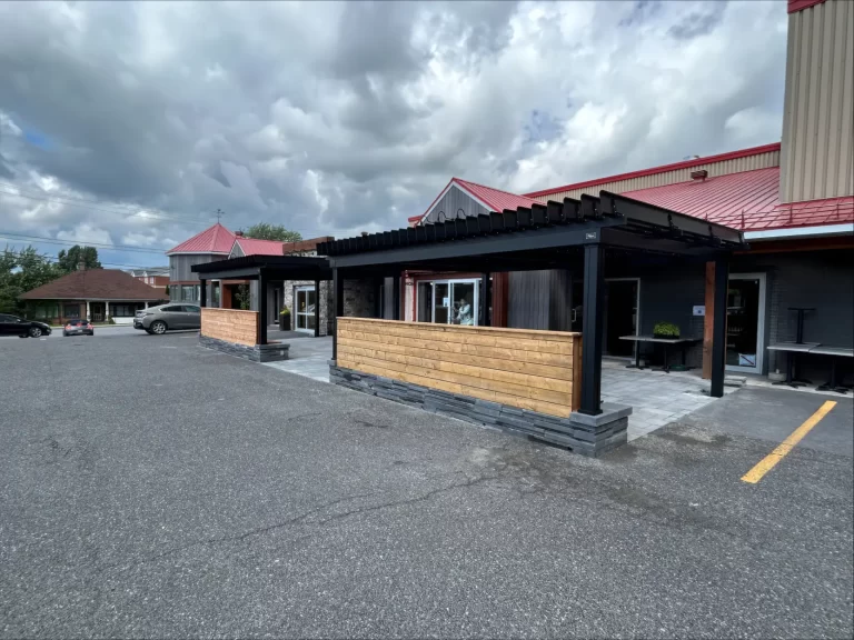 Terrasse et paravent de bois vus du stationnement, La Piazzetta à Granby