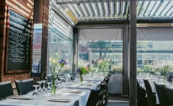 Salle de terrasse couverte, tables dressées et ardoise du menu, Le Pinocchio à Magog