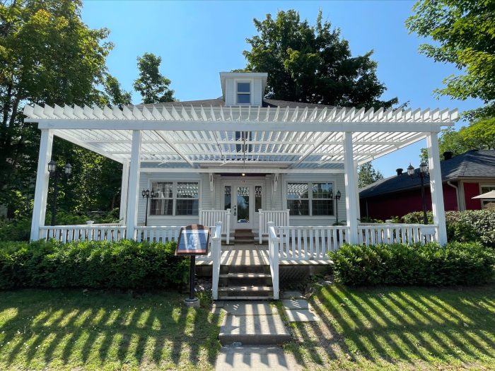 White pergola over the porch of the restaurant house, Pizzeria N°900 in Bromont