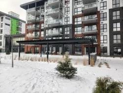 Pergola courant le long de la façade enneigée, Projet Citiluxx à Saint-Hubert