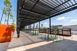 Longue terrasse de toit sous un couvert de lames, mobilier coloré, Quartier Général Condos à Montréal