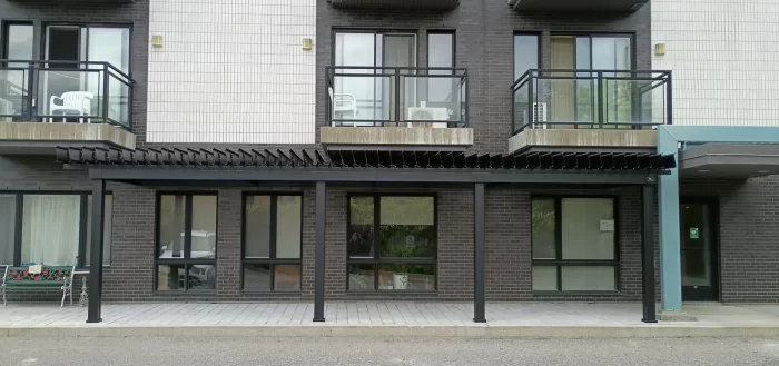 Pergola noire longeant la façade de la résidence, Résidence Bienvenue à Pierrefonds