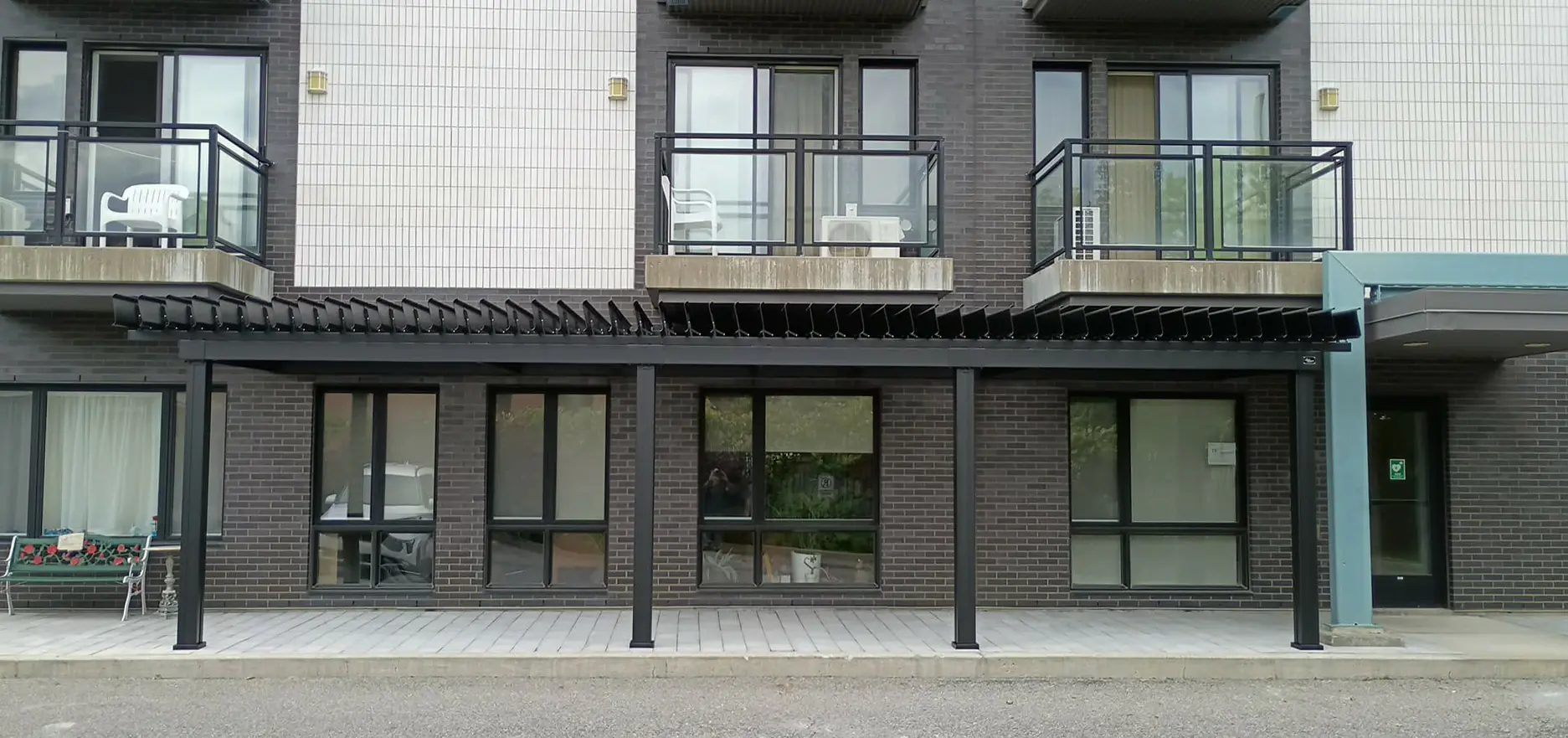 Pergola noire longeant la façade de la résidence, Résidence Bienvenue à Pierrefonds
