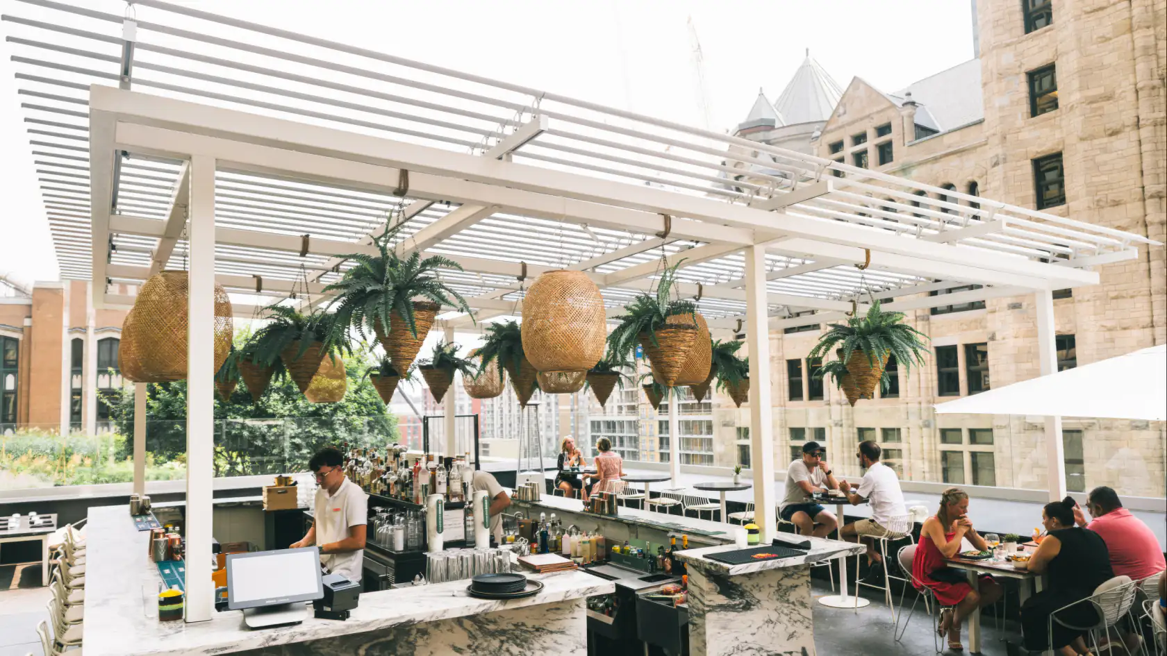 Rooftop terrace bar under a white louvered pergola, Restaurant Belvu in Montréal