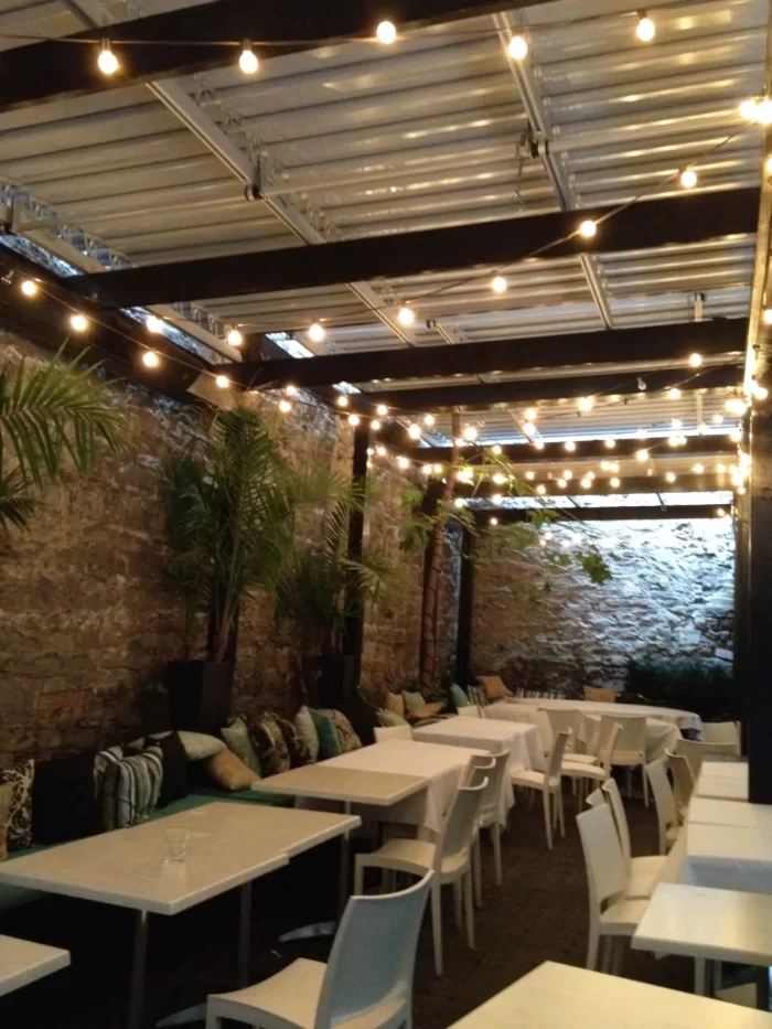 Salle de terrasse couverte, guirlandes et tables dressées, Restaurant Scarlet Exclusive à Montréal