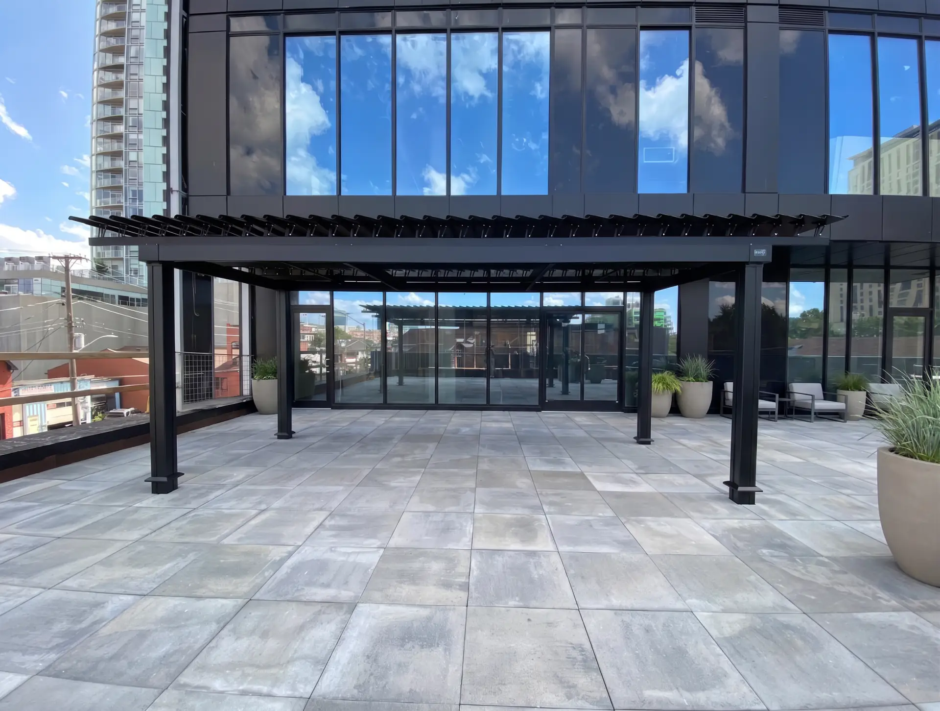 Pergola noire au-dessus de la terrasse près du bâtiment vitré, Soho Italia à Ottawa