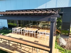 Tables under the terrace's open louvers, SunLouvre Pergolas in Granby