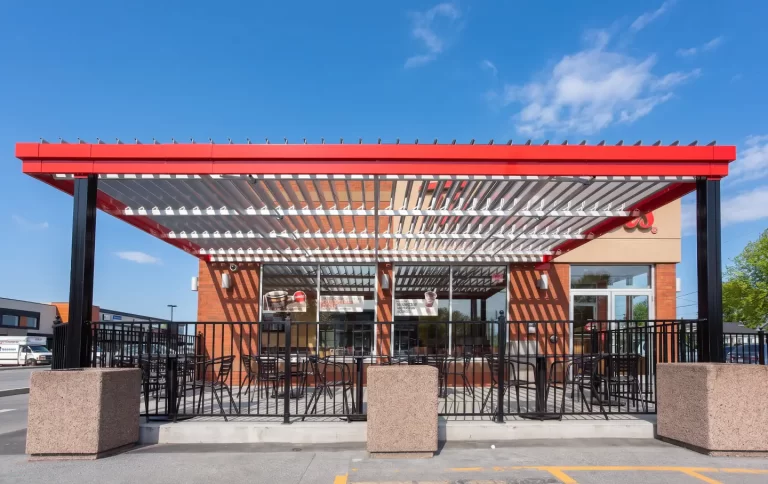 Lames blanches et structure rouge vues de face à l'entrée, Tim Hortons à Granby