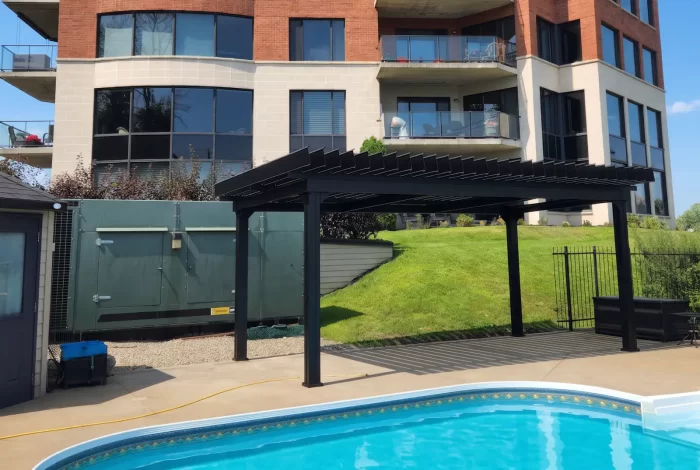 Black pergola on the lawn beside the pool, Les Tours du Château in Vaudreuil