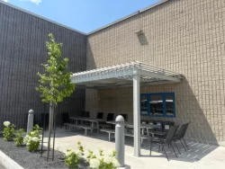 Cour et tables abritées par la pergola blanche, Société de transport de Sherbrooke
