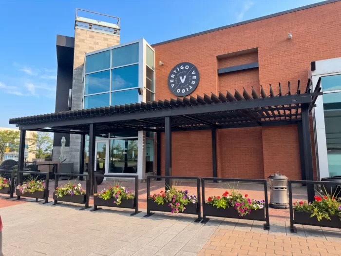Pergola noire au-dessus de la terrasse et de ses jardinières, Restaurant Vertigo à Laval